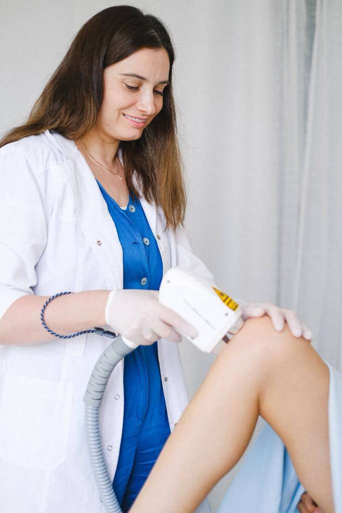 Lady doctor gives a treatment of joint pain.