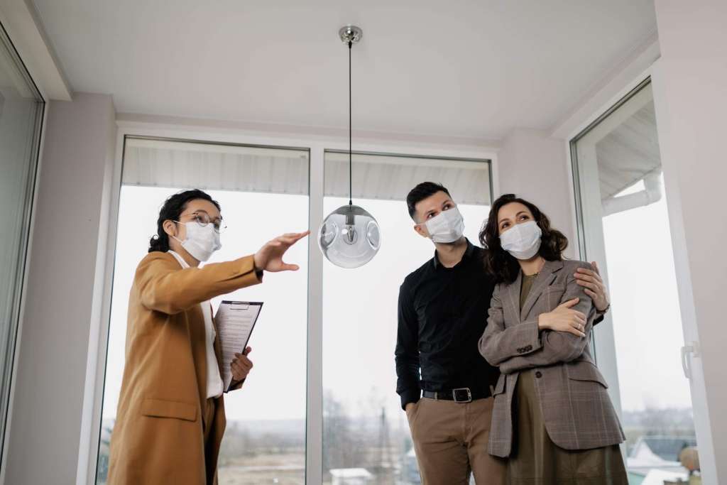 A lady explains the home details to couples.