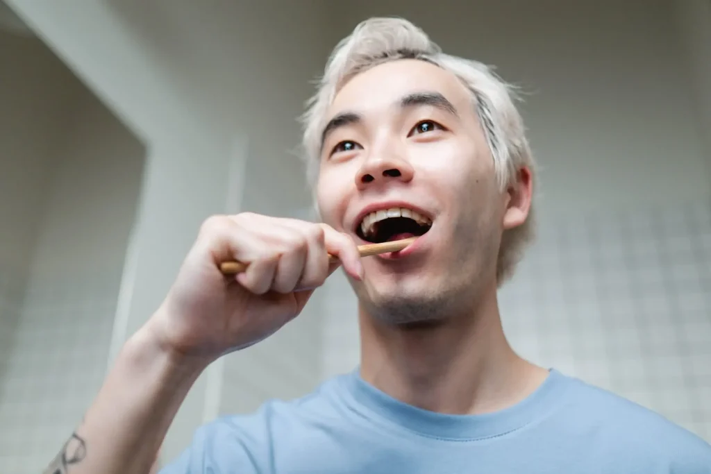 A man brushing his teeth to maintain oral hygiene.