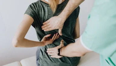 a woman is sitting on a white surface she have back pain she can message with her hands