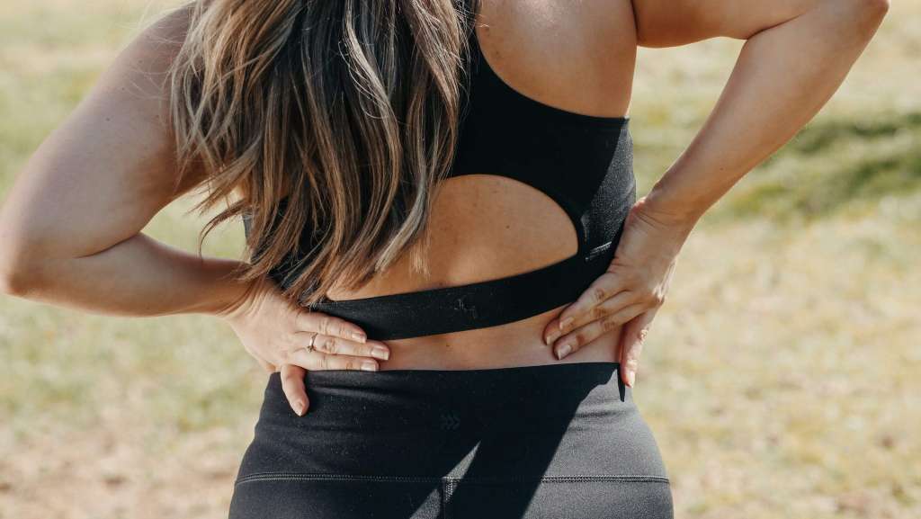 a woman with her back pain she messaged wih her hands.