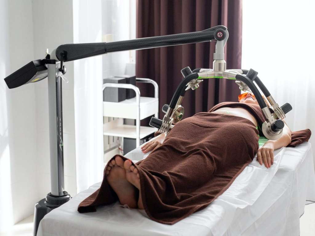 a women laying on a bed with a machine attached to it.
