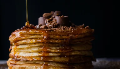 a stack of pancakes covered in syrup and chocolate.