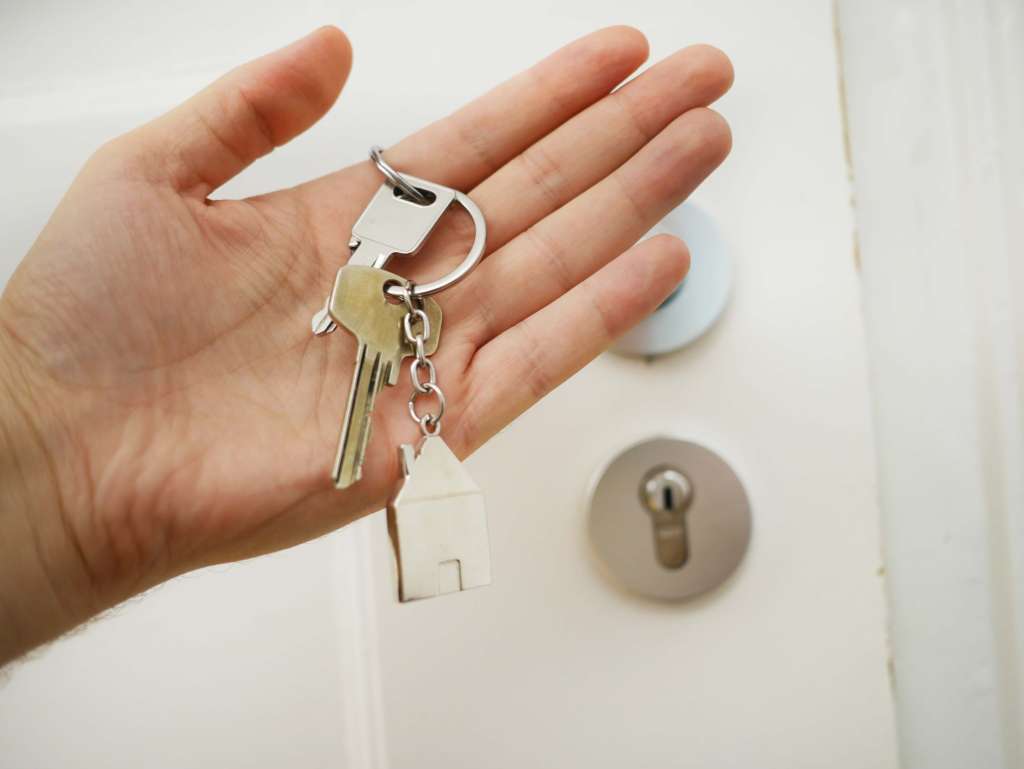 a hand holding a key to a door.